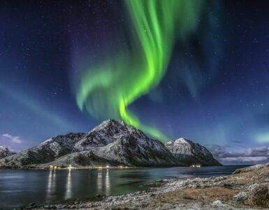 Green Aurora Borealis Over Snow Covered Mountain