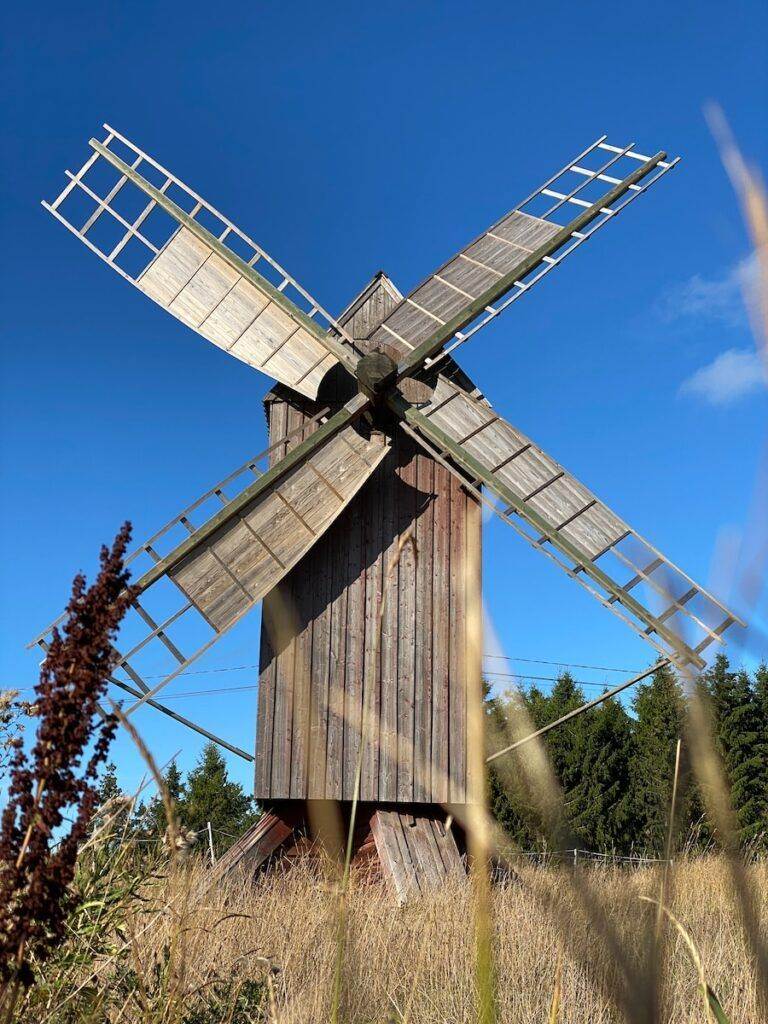 a windmill in a field with Morgan Lewis Windmill in the background