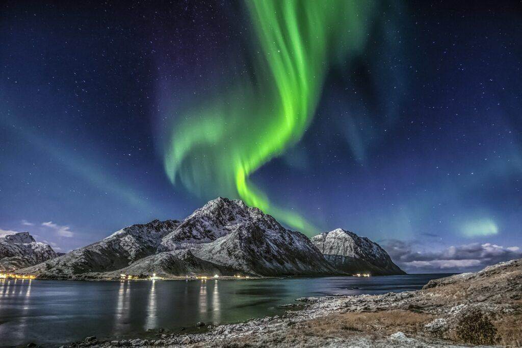 Green Aurora Borealis Over Snow Covered Mountain