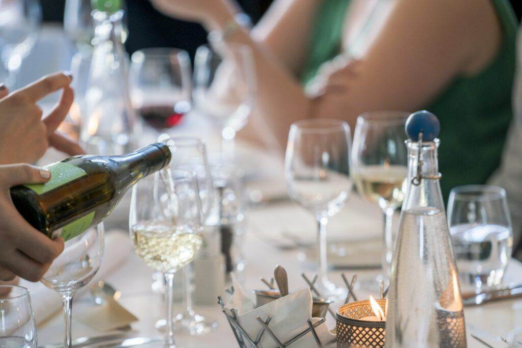 Person Pouring Wine on Clear Wine Glass