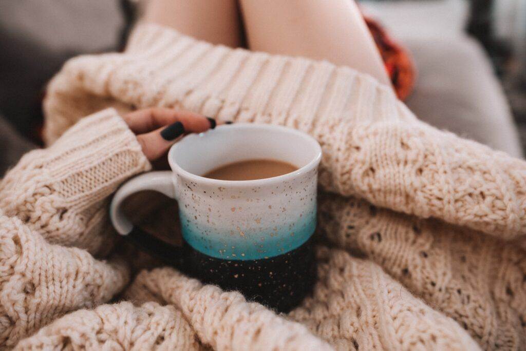 white ceramic mug on white knit textile