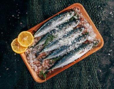 cooked steamed fish on rice inside orange plastic bowl