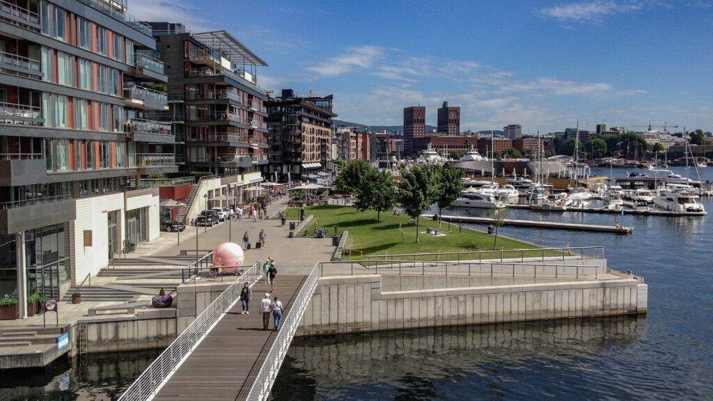 people walking on sidewalk near body of water during daytime