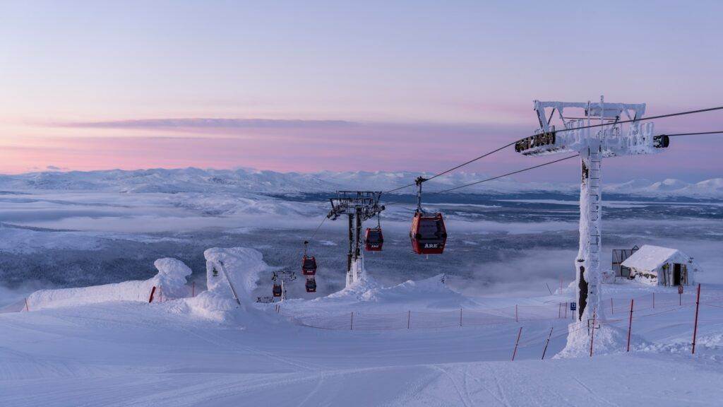 a ski lift going over a snow covered mountain