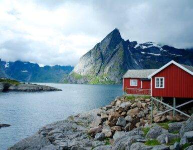 red and white wooden house in front of body of water