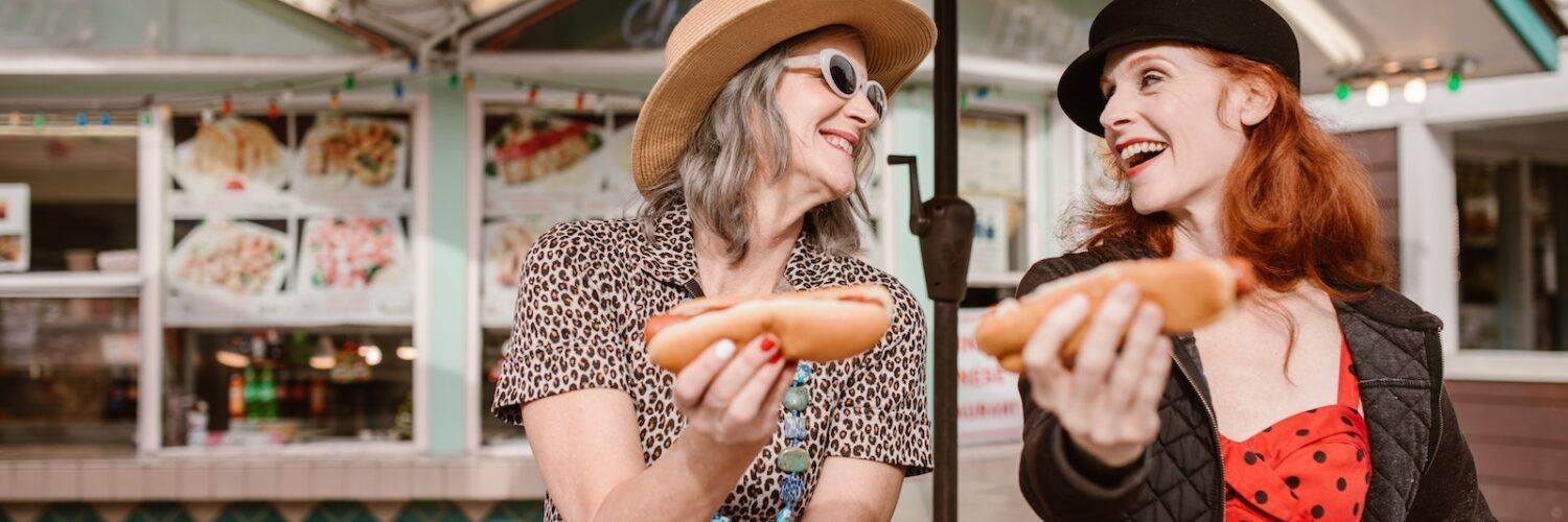 Two Women Holding Hotdogs