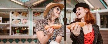 Two Women Holding Hotdogs