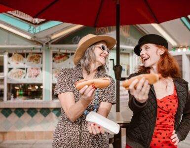 Two Women Holding Hotdogs