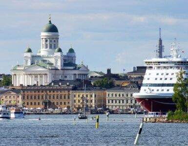 a large cruise ship in the water near a city