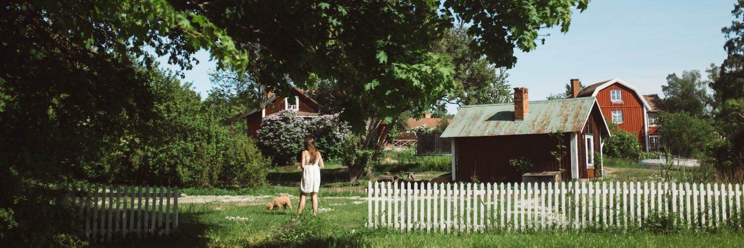 woman standing beside dog in green lawn