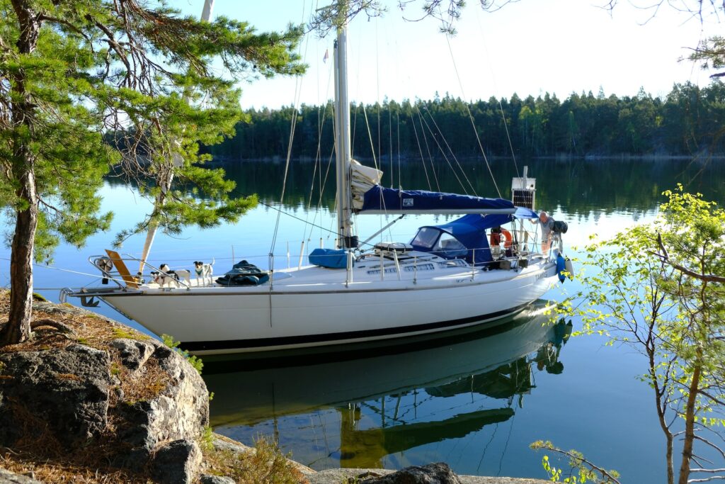 a sailboat is docked at the shore of a lake
